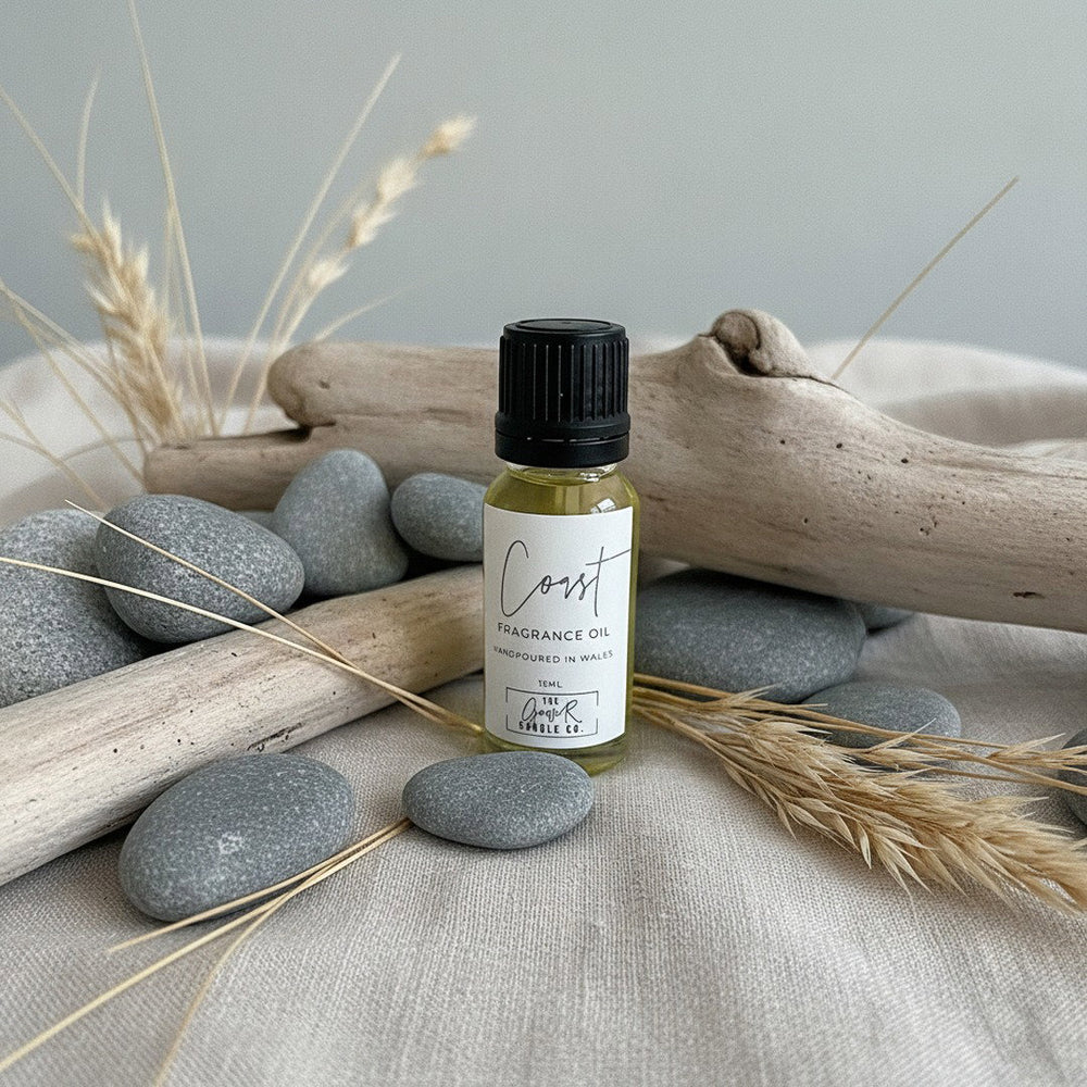 Coast Fragrance Oil by The Gower Candle Co. on grey sea pebbles and driftwood with dried beach grasses