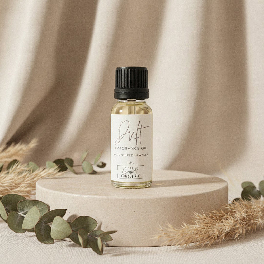 Drift Fragrance Oil by The Gower Candle Co. on a beige stone pedestal with dried eucalyptus and pampas grass