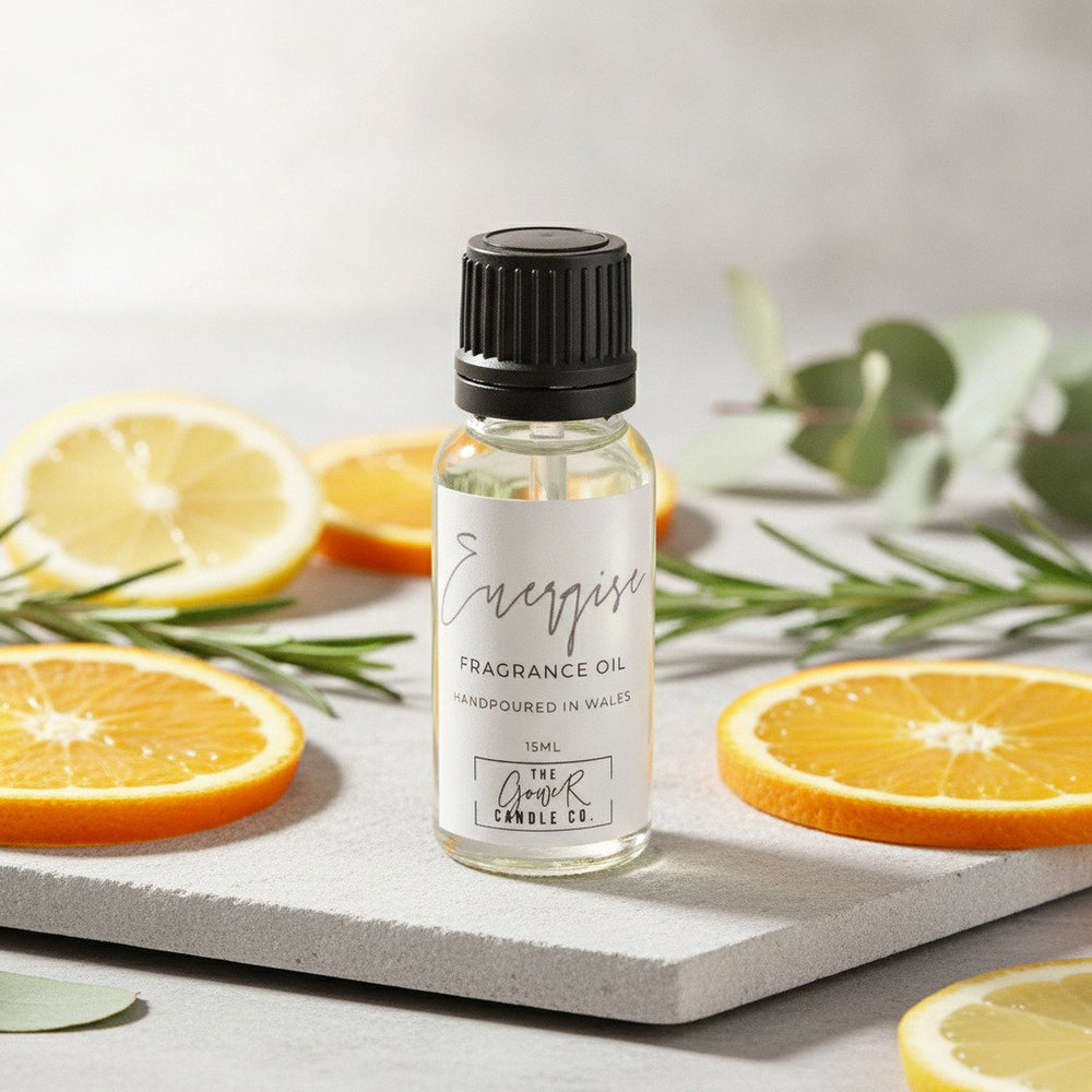 Energise Fragrance Oil by The Gower Candle Co. on pale stone with fresh citrus slices and eucalyptus