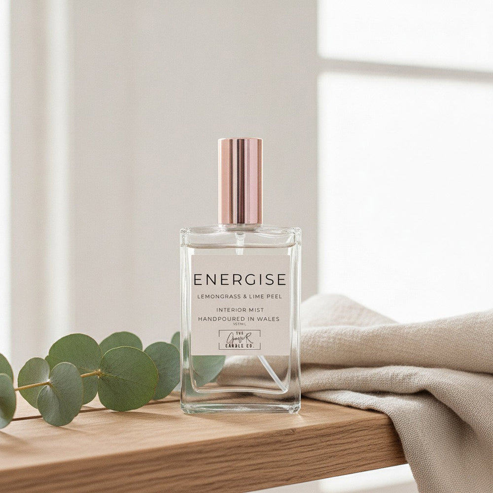 Energise Room Mist by The Gower Candle Co. on a light oak shelf with fresh eucalyptus and folded linen
