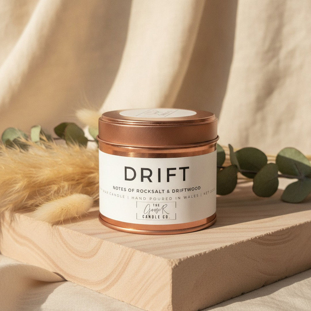 Drift Rose Gold Soy Candle by The Gower Candle Co. on sandstone with dried pampas grass and eucalyptus