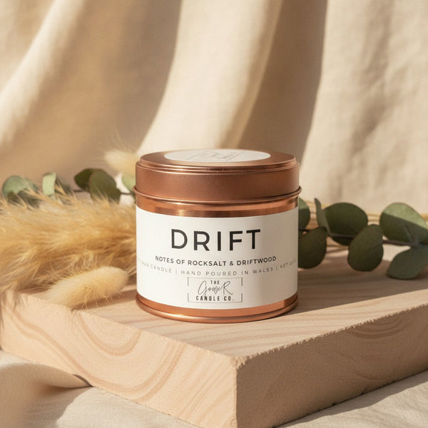 Drift Rose Gold Soy Candle by The Gower Candle Co. on sandstone with dried pampas grass and eucalyptus