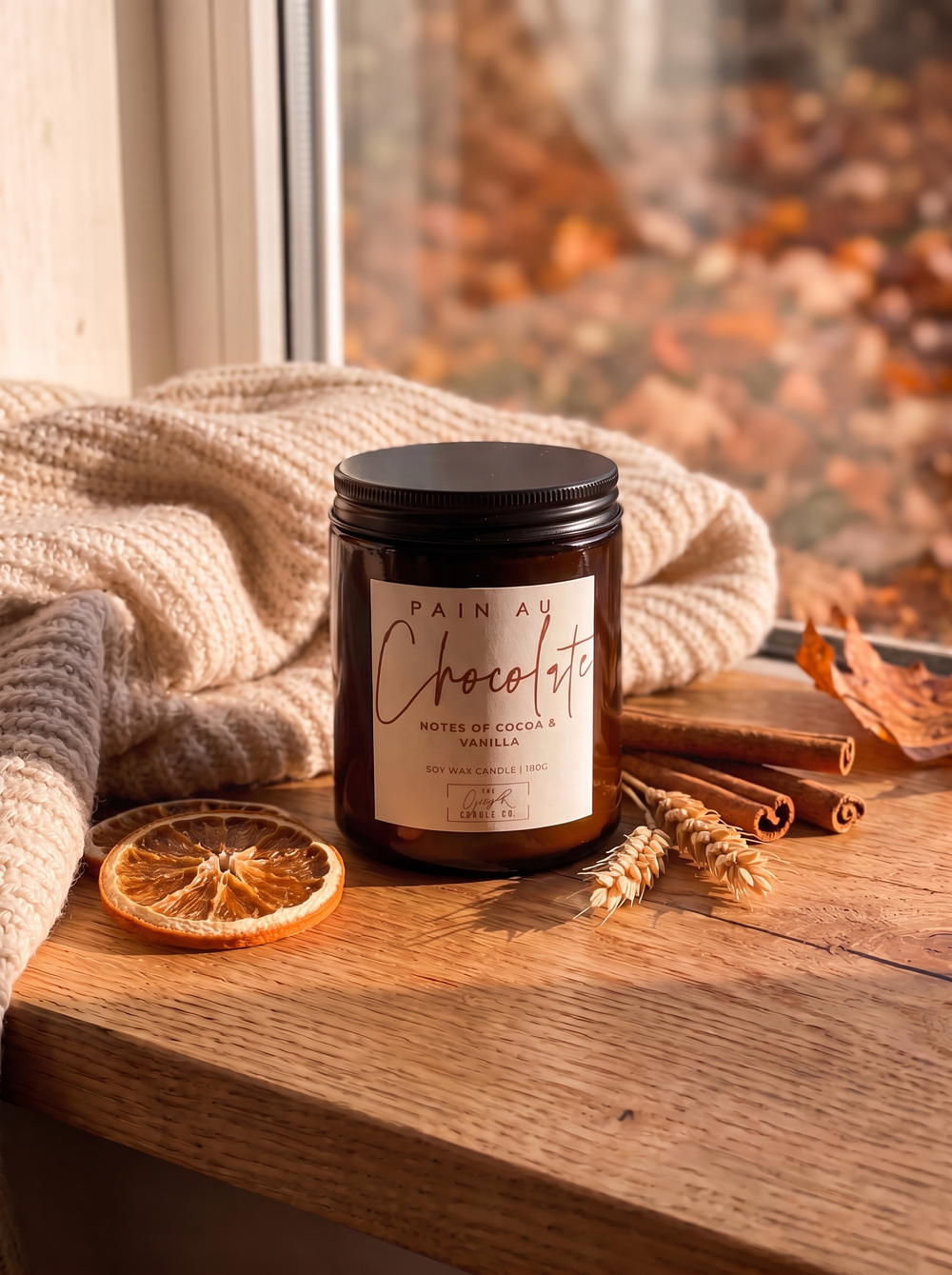Pain au Chocolat candle styled in a cosy autumn window scene